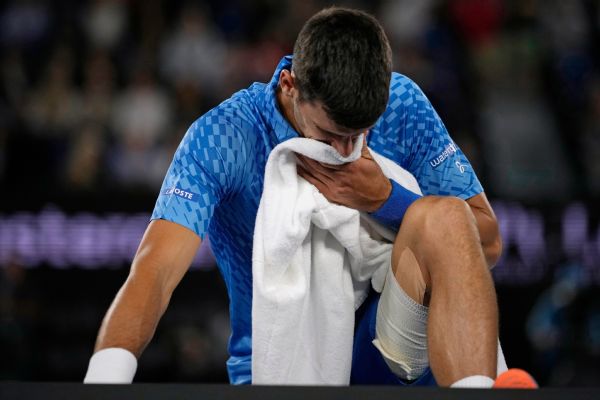 Djokovic overcomes injury, heckler to advance
